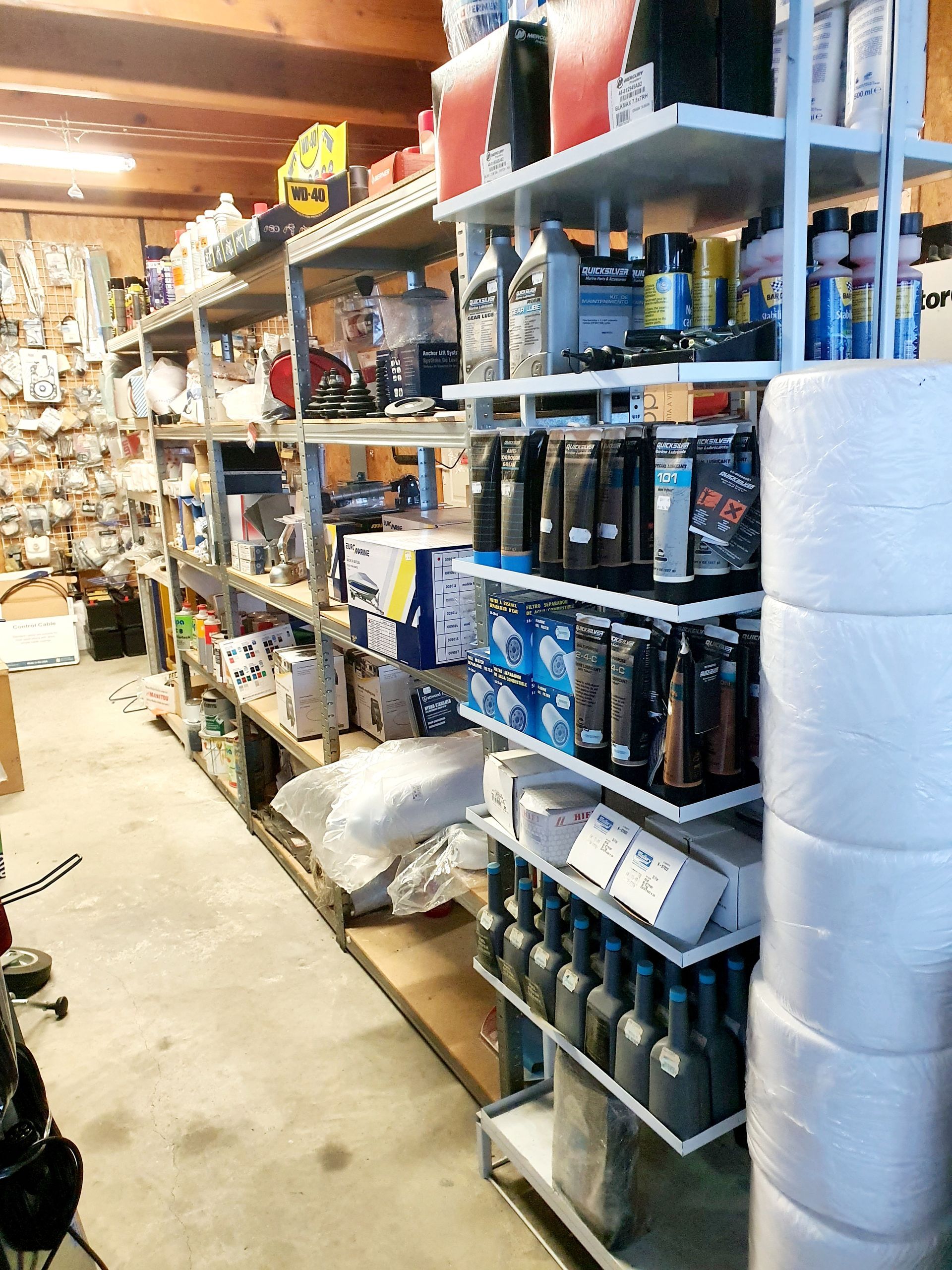Étagères du magasin Occaméca avec huiles, lubrifiants Quicksilver, filtres et pièces d’entretien.